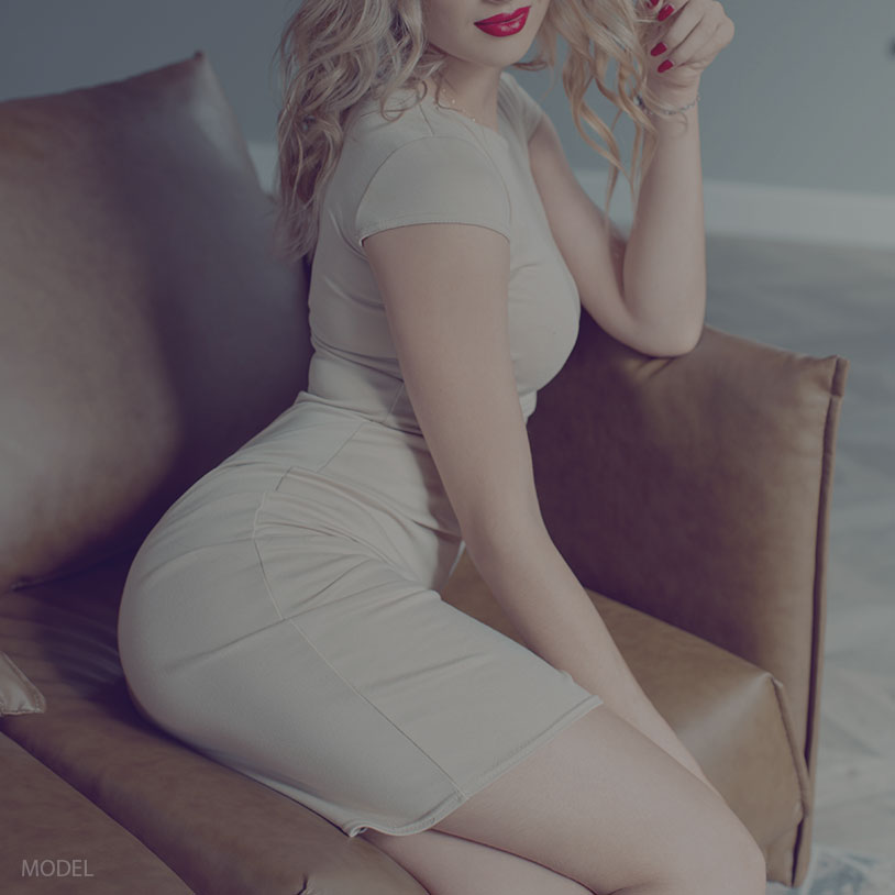attractive blonde woman sitting in a chair, BBL surgery Orlando